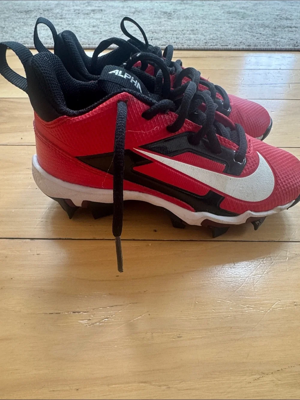 Nike Kids' Red and Black cleats with White Swoosh